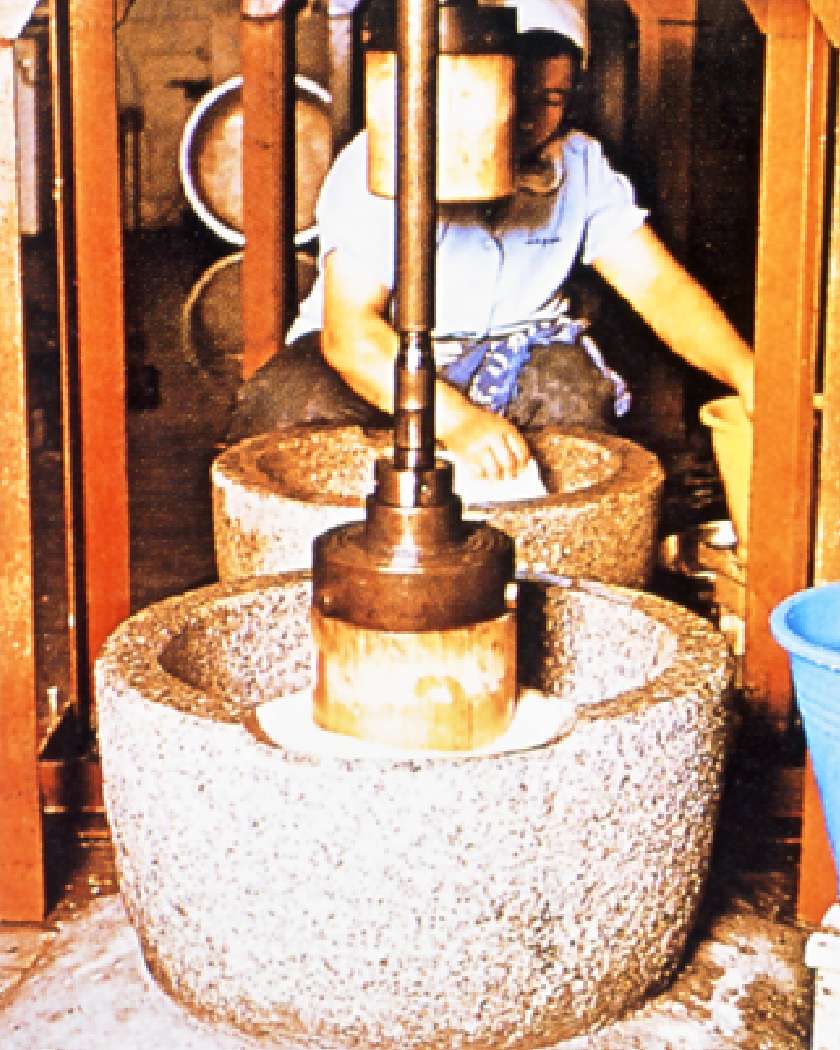 石臼と杵で餅をつく製造風景の画像